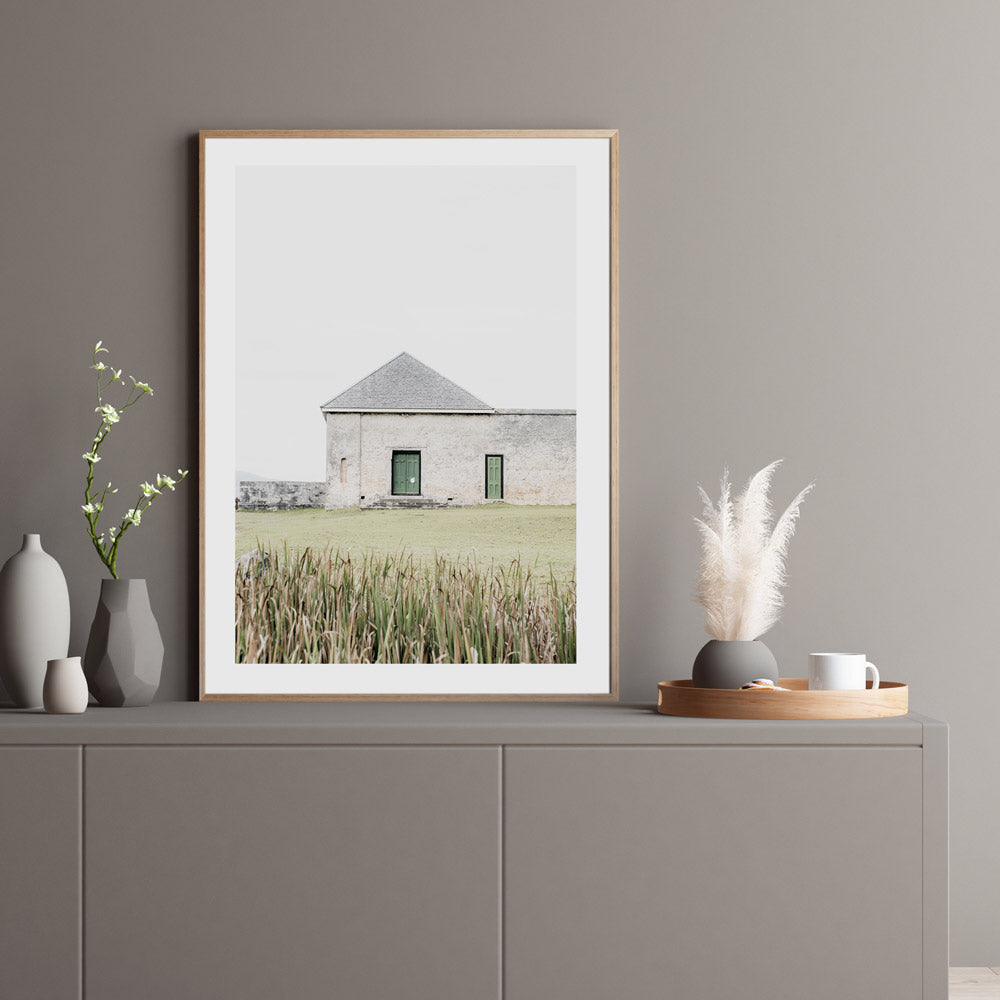 A house on Norfolk Island - a golden framed photo of a building with green doors