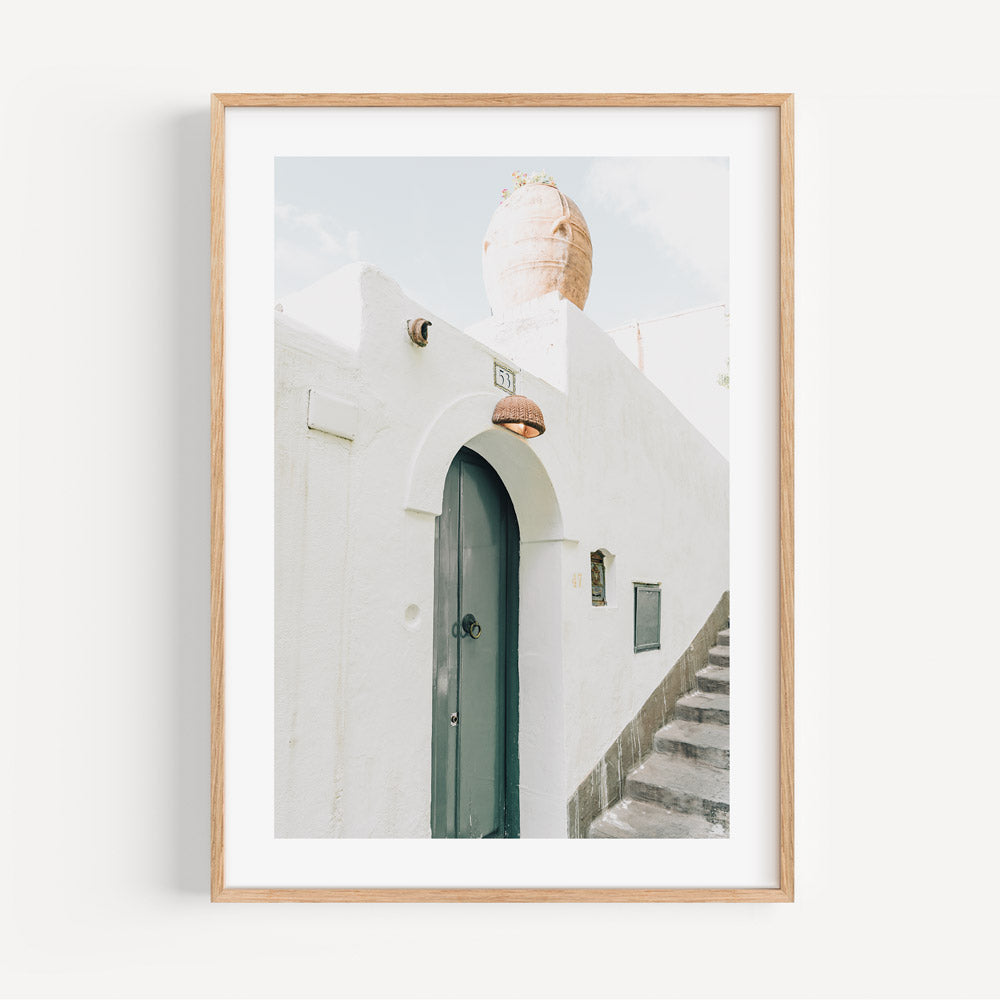 Artwork of a white framed photo capturing a doorway and stairs in Italy