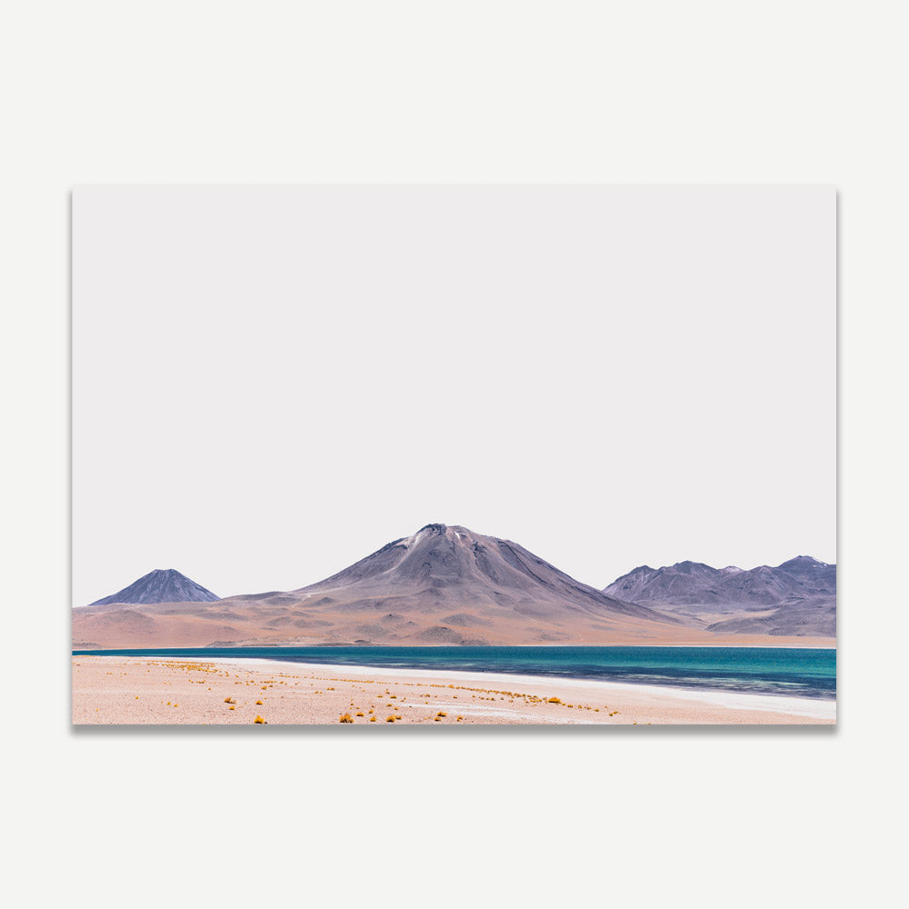 A landscape photograph featuring mountains and a desert area with a body of water in the foreground.