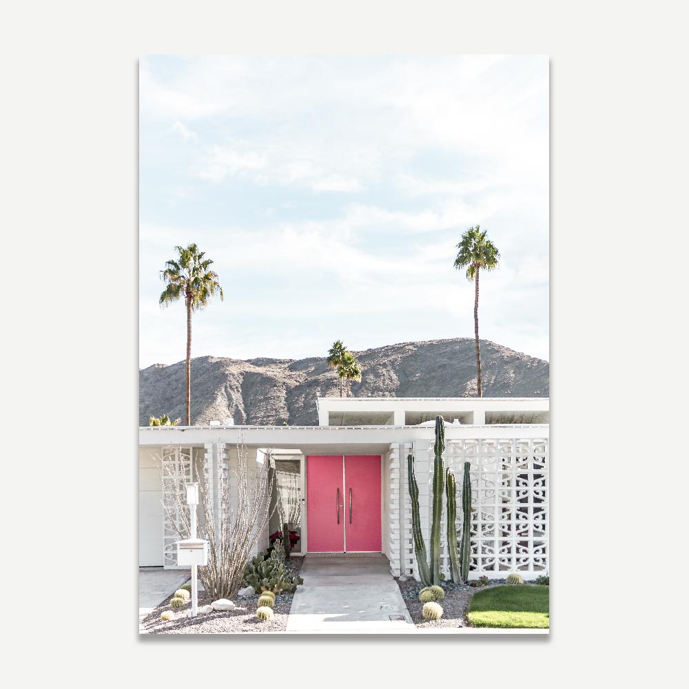 Midcentury modern home with pink door and cacti, palm trees, and mountains in Palm Springs - stunning for wall art decor.
