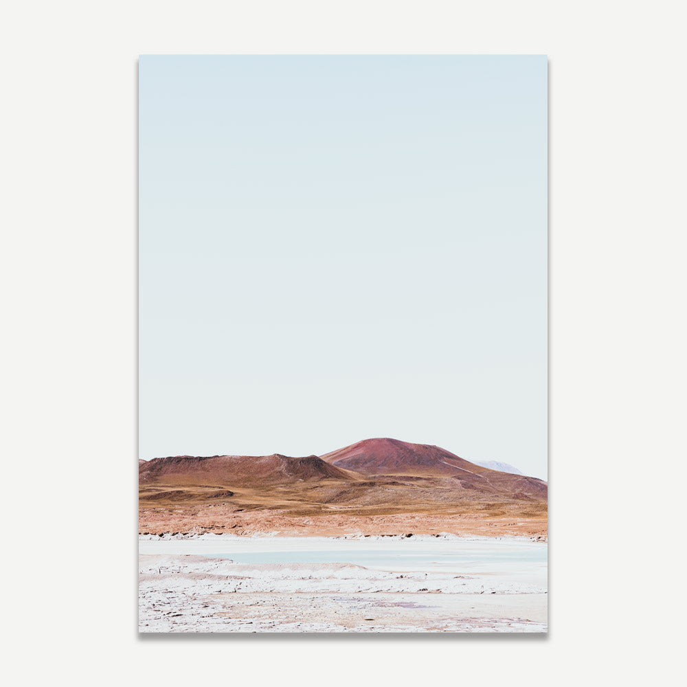 A landscape photograph featuring a desert scene with orange and blue hues, likely representing the Atacama region in Chile.