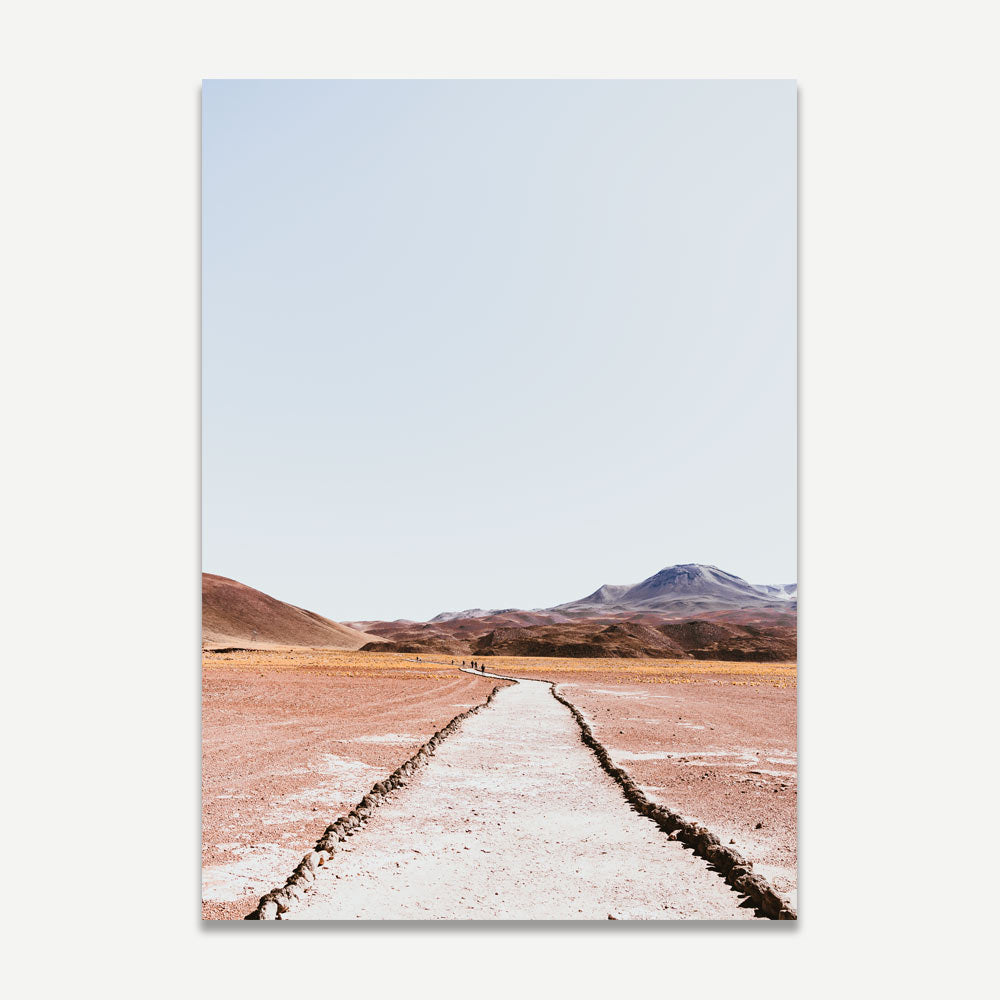 A landscape photograph featuring a dirt track leading towards mountains, with a predominantly red and blue color palette.