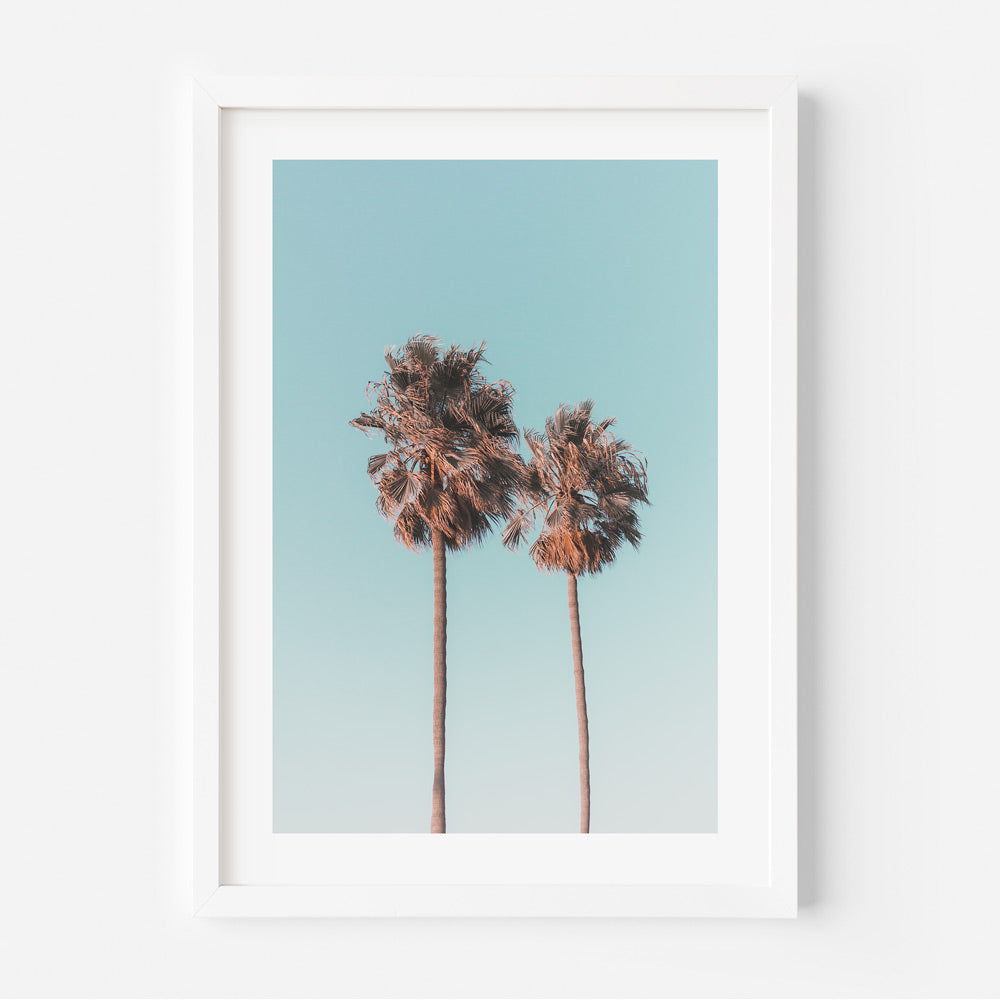 California Dreaming: Twin palm trees framed against a vivid blue sky, perfect for wall art and home decor.